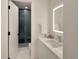 Bright bathroom with modern vanity, illuminated mirror, and tiled shower at 418 Steele St, Denver, CO 80206