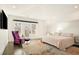 Bright bedroom with balcony access, stylish furnishings, large windows, and dark hardwood flooring at 418 Steele St, Denver, CO 80206