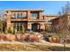 Striking two-story brick home with black iron gate, balcony, mature trees and meticulously manicured landscaping at 418 Steele St, Denver, CO 80206