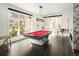 Spacious game room with a pool table, hardwood floors, and large windows offering plenty of natural light at 418 Steele St, Denver, CO 80206