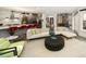 Open-concept living room boasts hardwood floors, modern lighting, and a sleek kitchen with red bar stools and wine storage at 418 Steele St, Denver, CO 80206