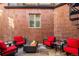 Red brick patio with a fire pit and comfortable red swivel chairs at 418 Steele St, Denver, CO 80206