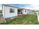 Backyard view of covered patio with seating, grill, white fence and green lawn at 5072 Silver Hare Ln, Castle Rock, CO 80104