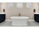 Bright bathroom featuring dual vanities, a soaking tub, and modern geometric tile at 5072 Silver Hare Ln, Castle Rock, CO 80104
