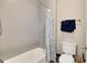 Clean bathroom with a gray tiled shower/tub, a modern toilet, and neutral decor at 5072 Silver Hare Ln, Castle Rock, CO 80104