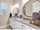 Stylish bathroom featuring dual round mirrors and a white vanity with gold hardware at 5072 Silver Hare Ln, Castle Rock, CO 80104