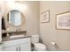 Cozy half bathroom with a vanity, round mirror, toilet, and neutral color scheme at 5072 Silver Hare Ln, Castle Rock, CO 80104