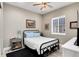 Inviting bedroom featuring a black iron bed, light hardwood floors, and soft lighting at 5072 Silver Hare Ln, Castle Rock, CO 80104