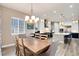 Open-concept dining room and kitchen featuring white cabinets, modern appliances, and an island with counter seating at 5072 Silver Hare Ln, Castle Rock, CO 80104