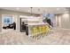 Bright kitchenette with yellow bar stools, stainless steel appliances, and views to stairs and living area at 5072 Silver Hare Ln, Castle Rock, CO 80104