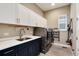 Well-organized laundry room with a sink, cabinets, and modern washer and dryer at 5072 Silver Hare Ln, Castle Rock, CO 80104
