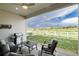 Covered patio with comfortable seating, a grill, and views of a green lawn and distant trees at 5072 Silver Hare Ln, Castle Rock, CO 80104