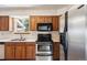 A functional kitchen featuring wood cabinets and stainless-steel appliances at 9908 Garfield Ct, Thornton, CO 80229
