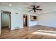 Open-concept living room featuring wood floors, ceiling fan, and view into the kitchen at 4866 S Dudley St # 2, Littleton, CO 80123