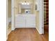 Bright bathroom with wood floors, white vanity, and an extra built-in shelving unit at 5622 E Weaver Cir, Centennial, CO 80111