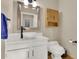 Modern powder room with vessel sink, cabinet storage, and a decorative mirror at 5622 E Weaver Cir, Centennial, CO 80111
