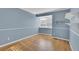 Cozy bedroom with hardwood floors, fresh blue paint, window with blinds, and built in shelving at 5622 E Weaver Cir, Centennial, CO 80111
