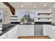 Modern kitchen featuring white cabinets, granite countertops, stainless steel appliances, and floating shelves at 5622 E Weaver Cir, Centennial, CO 80111