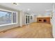 Spacious living room with hardwood floors, brick fireplace, and lots of natural light from large windows at 5622 E Weaver Cir, Centennial, CO 80111