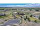 Aerial view showcasing the property's circular driveway, lush landscaping, and surrounding farmland at 55610 E 40Th Ave, Strasburg, CO 80136