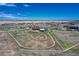 Aerial view of a property with riding trails, surrounded by white fencing and open fields at 55610 E 40Th Ave, Strasburg, CO 80136