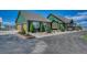 Green home exterior with an attached garage, mature trees, and manicured landscaping at 55610 E 40Th Ave, Strasburg, CO 80136