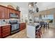 Well-equipped kitchen featuring an island with seating, stainless appliances, and a connected dining area at 55610 E 40Th Ave, Strasburg, CO 80136