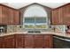 Updated kitchen features granite countertops, mosaic backsplash, stainless dishwasher, and large arched window at 55610 E 40Th Ave, Strasburg, CO 80136