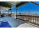 Covered porch with outdoor furniture overlooking a sprawling lawn with an American flag at 55610 E 40Th Ave, Strasburg, CO 80136
