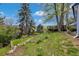 Landscaped backyard with grass, trees, mulch, foliage, and a raised wooden deck at 10508 W Chautauga Mtn, Littleton, CO 80127