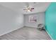 This empty bedroom has hard floors, a ceiling fan, window, and accent wall at 9759 Lane St, Thornton, CO 80260