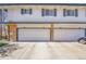 Four garages in townhouse complex with brick pillars and visible address numbers on garage doors at 9759 Lane St, Thornton, CO 80260