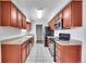 Galley-style kitchen with modern stainless steel appliances and wood cabinetry at 9759 Lane St, Thornton, CO 80260