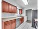 Functional kitchen with stainless steel appliances, wood cabinets, and a view into the laundry room at 9759 Lane St, Thornton, CO 80260