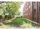 Brick apartment building with a well-manicured backyard featuring green lawn and mature trees at 1060 N Washington St # 301, Denver, CO 80203