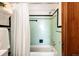 Bathroom with light green tiling and a white bathtub and shower and a vintage aesthetic at 1060 N Washington St # 301, Denver, CO 80203