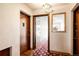 Hallway with a decorative floral-patterned carpet, doors, and textured walls under a vintage light fixture at 1060 N Washington St # 301, Denver, CO 80203