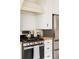 Close-up of a kitchen featuring stainless steel range, white cabinetry, and stylish finishes at 1060 N Washington St # 301, Denver, CO 80203