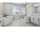 Bright bathroom featuring a large soaking tub, walk-in shower, and modern vanity with great natural light at 13710 Emerald Lake St, Parker, CO 80138