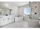 Bright bathroom featuring a large soaking tub, walk-in shower, and sleek vanity with modern fixtures at 13710 Emerald Lake St, Parker, CO 80138