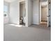 Bright bedroom with neutral carpet leads to bathroom, offering a serene living space at 13710 Emerald Lake St, Parker, CO 80138