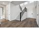 A bright and airy entryway featuring a staircase with black railings and wood-look flooring at 13710 Emerald Lake St, Parker, CO 80138