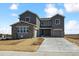A charming new two-story home featuring stone accents, gray siding, a driveway, and a manicured lawn at 13710 Emerald Lake St, Parker, CO 80138