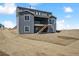 New construction with a modern gray exterior, backyard, and a second-story covered deck at 13710 Emerald Lake St, Parker, CO 80138