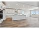A modern, open-concept kitchen featuring a large island, white cabinetry, and wood flooring at 13710 Emerald Lake St, Parker, CO 80138