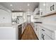 Modern kitchen with white cabinets, stainless steel appliances, and a large island at 13710 Emerald Lake St, Parker, CO 80138