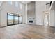 A bright living room featuring a soaring stone fireplace, an abundance of natural light, and stylish wood flooring at 13710 Emerald Lake St, Parker, CO 80138
