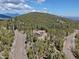 Breathtaking aerial view of a home nestled amongst trees with scenic mountain views at 32091 Black Widow Dr, Conifer, CO 80433