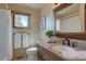Cozy bathroom featuring a wood framed mirror and granite counters and a window at 32091 Black Widow Dr, Conifer, CO 80433