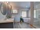 Spa-like bathroom with a soaking tub, dual vanity, and a glass-enclosed shower at 32091 Black Widow Dr, Conifer, CO 80433
